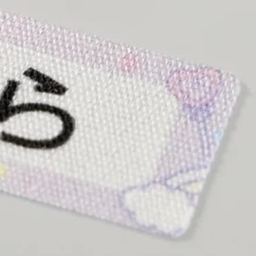 Close-up of a Cotton Label — a visible woven cotton weave with the printed name sitting in the fabric