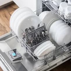 Dishes and cutlery inside a dishwasher rack